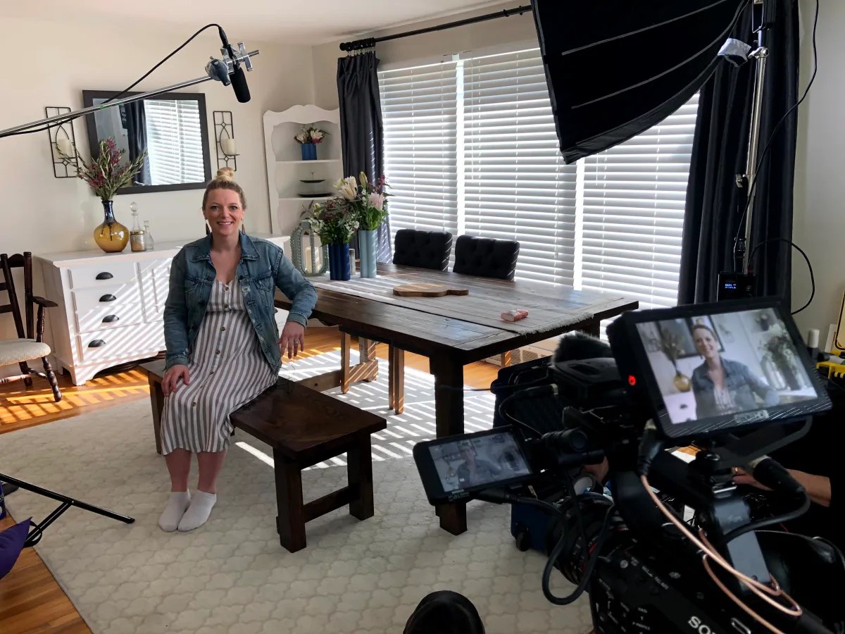 Jackie Hausler sitting at dining room table with camera equipment